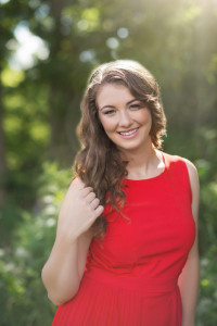 backlit sun filled senior picture in red dress