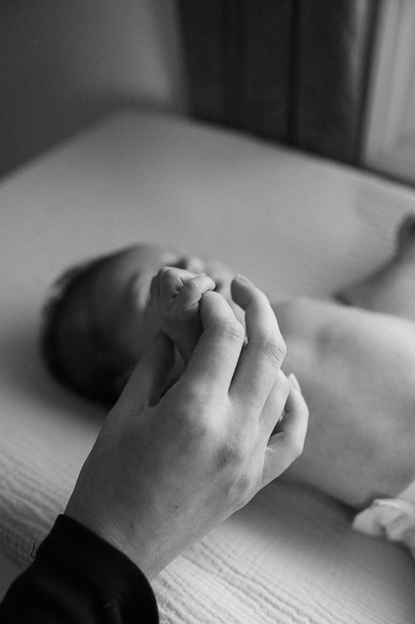 Newborn baby grabbing onto to mom's finger